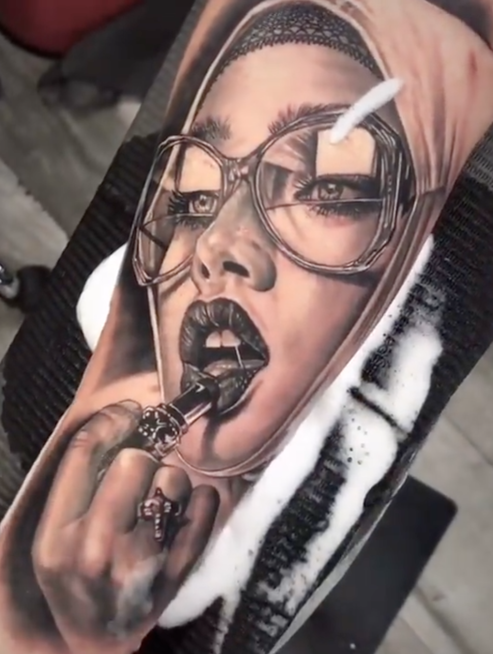 Realistic portrait tattoo of a woman applying lipstick