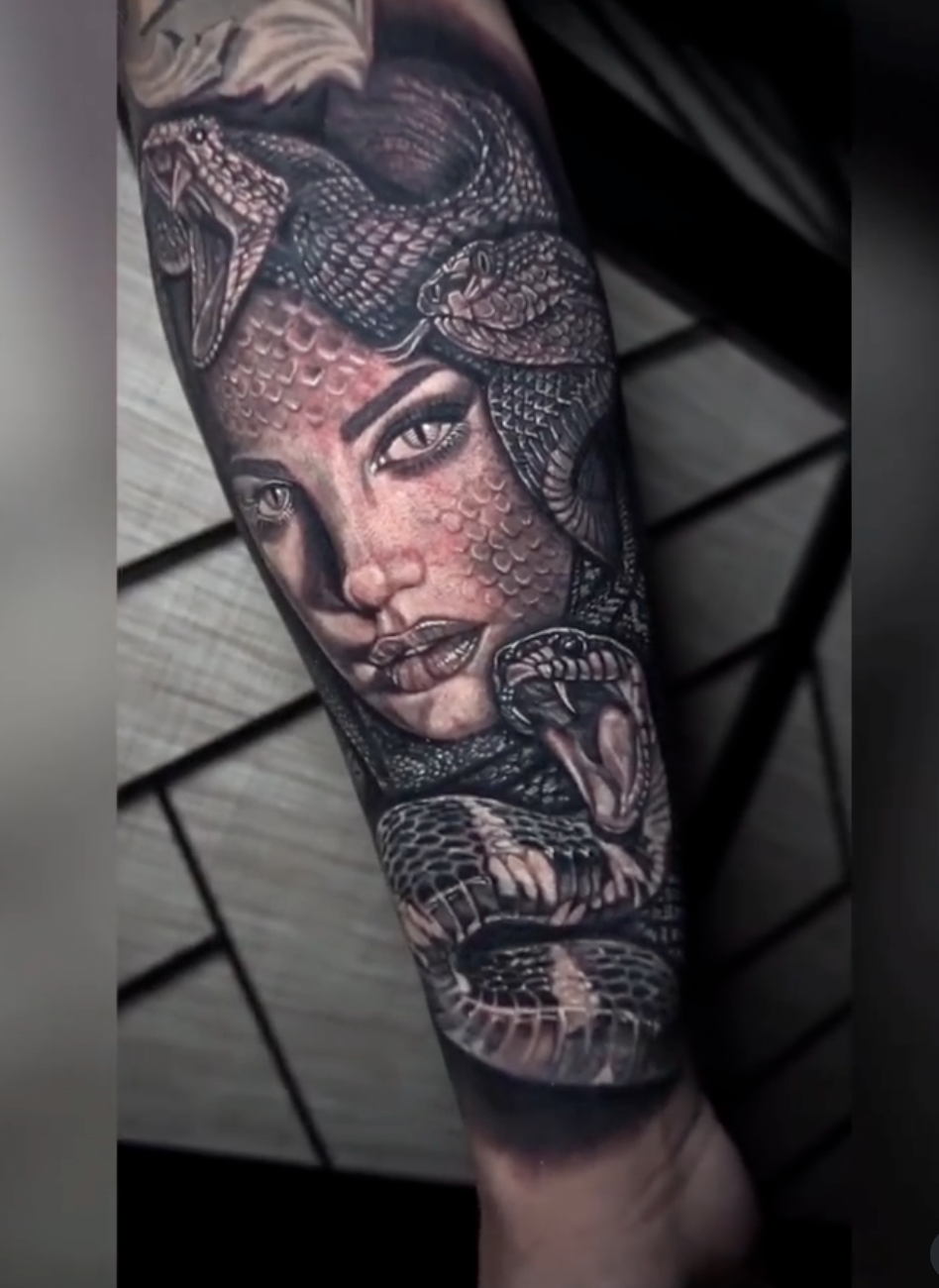 Black-and-grey Medusa portrait tattoo surrounded by snakes