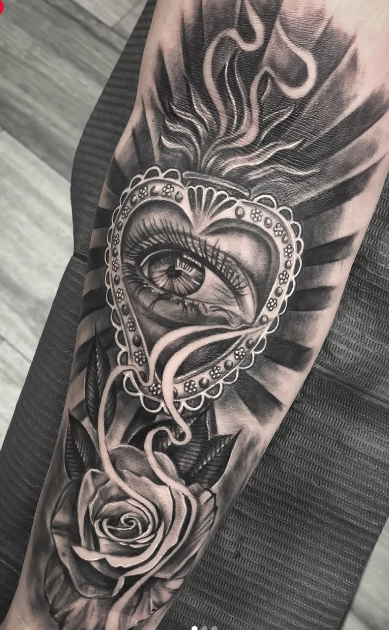 Black-and-grey eye, heart mirror, ribbon, and rose tattoo