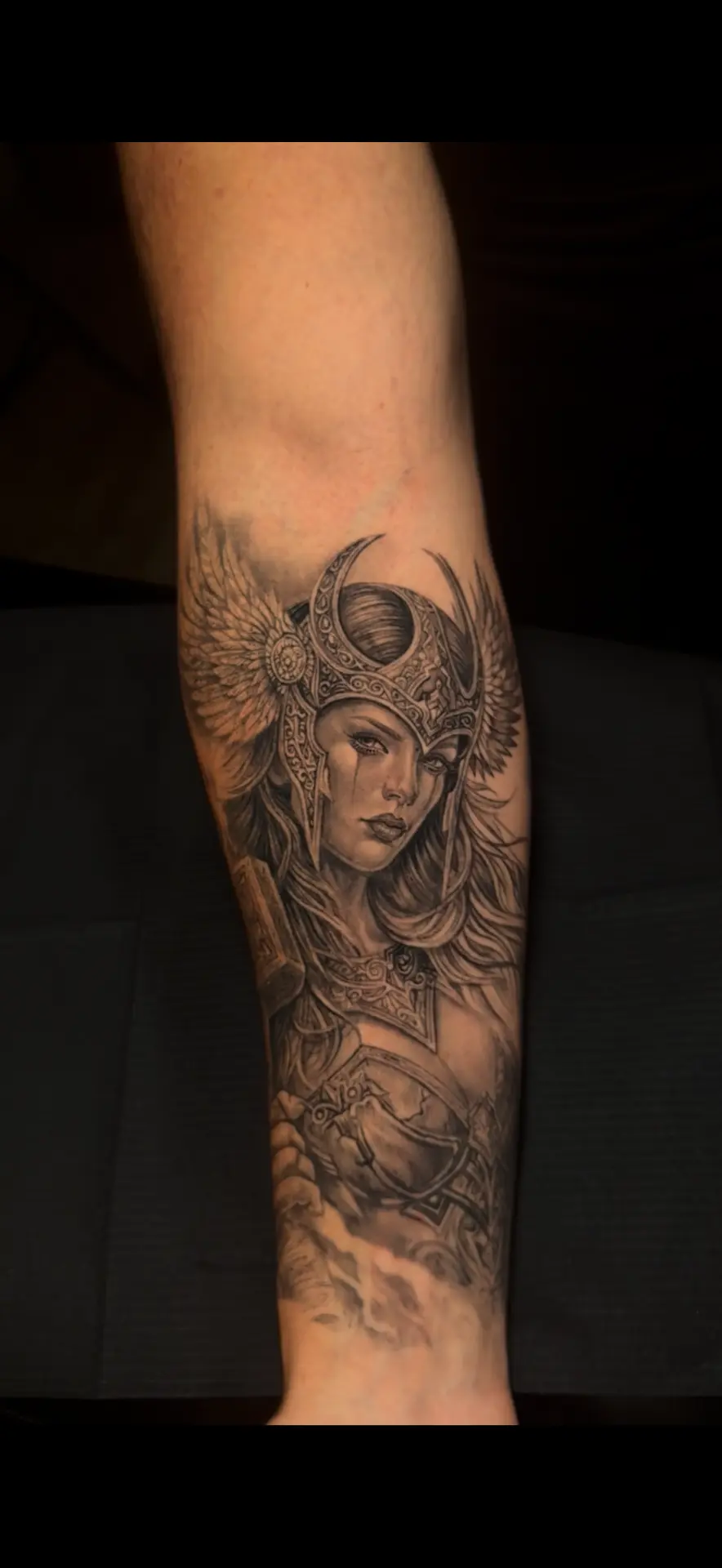 Black-and-grey armored warrior woman forearm tattoo