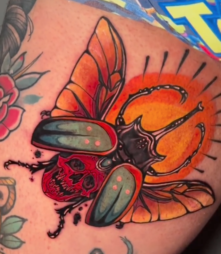 Color neo-traditional beetle tattoo with a red skull