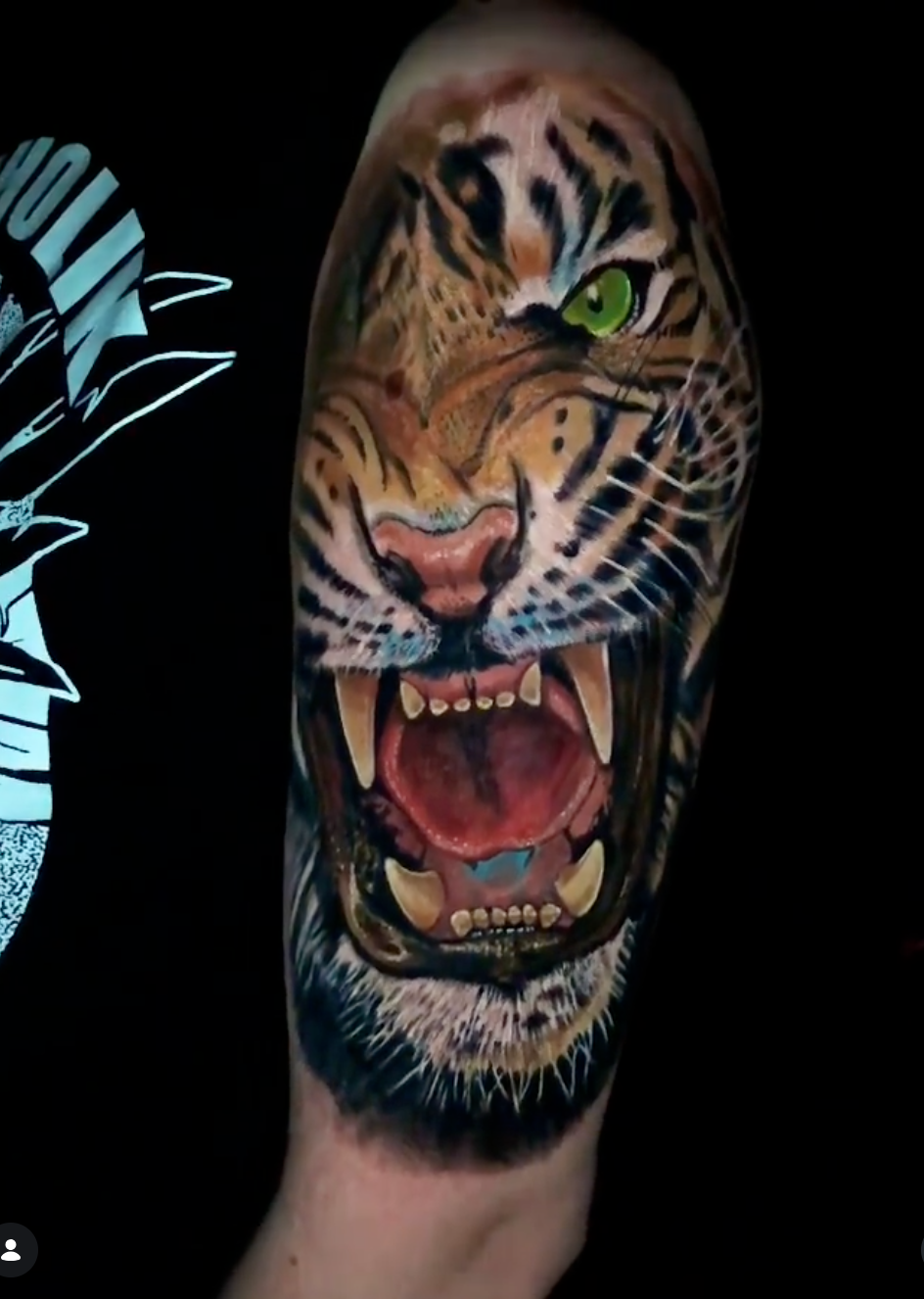 Realistic color roaring tiger tattoo with vivid green eyes