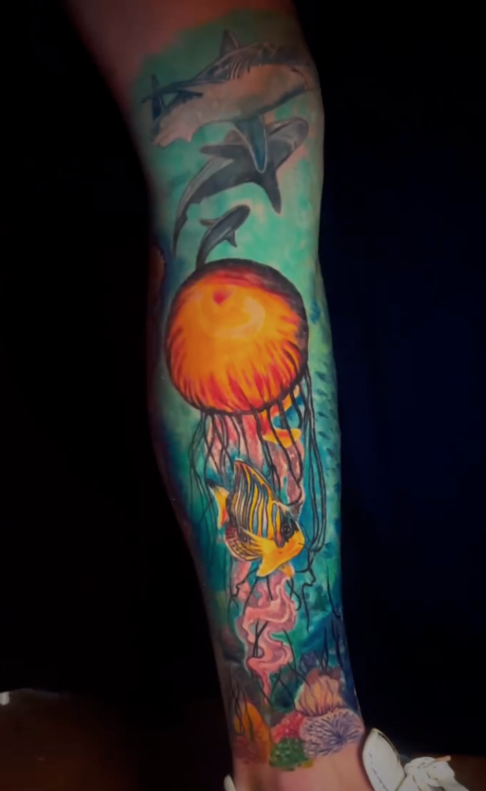 Color underwater tattoo with a jellyfish, tropical fish, and sharks